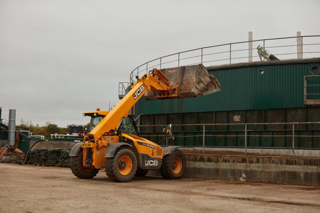 A JCB telehandler feeding material into the AD Plant